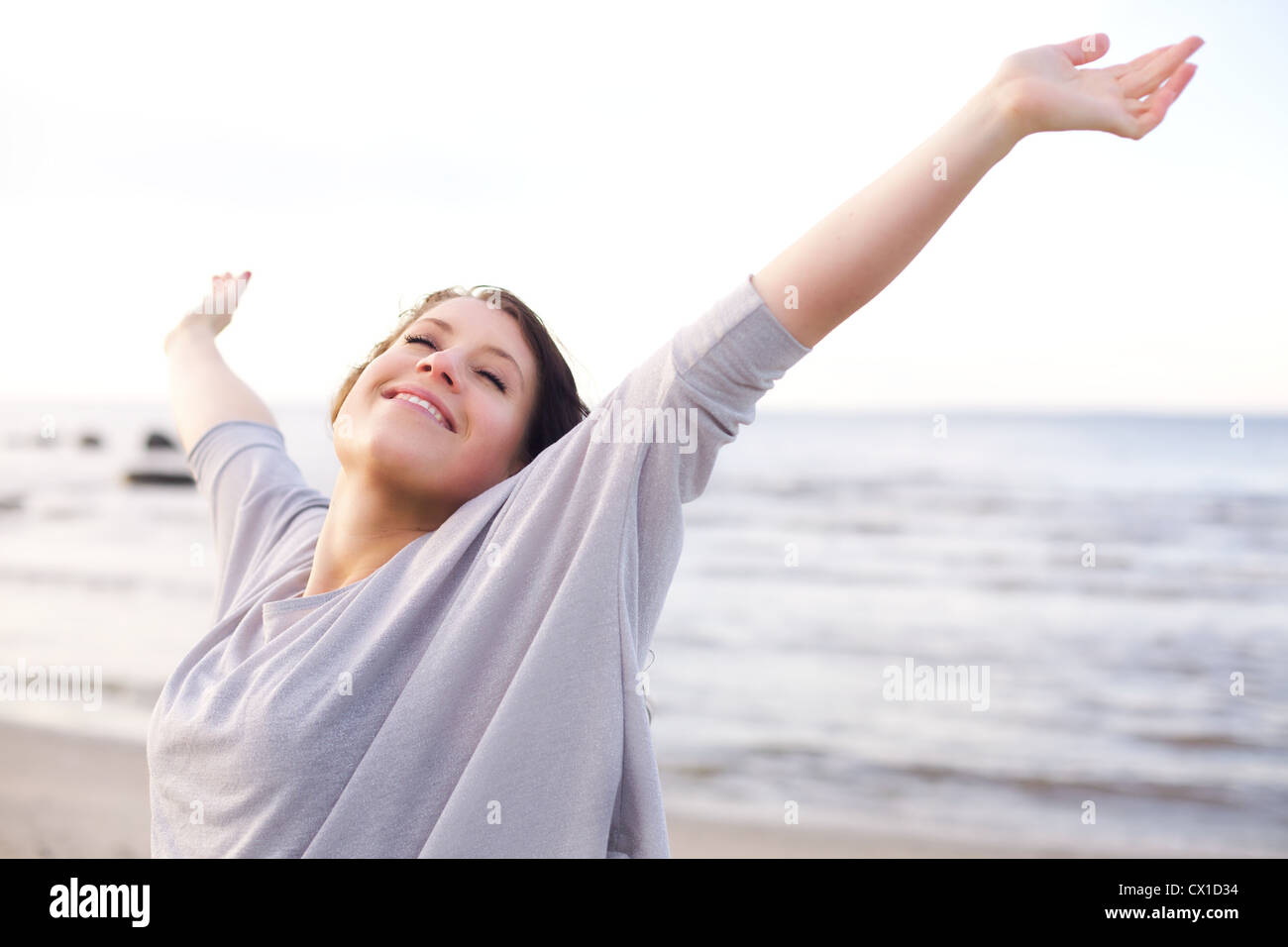 Femme étendant ses bras pour profiter de l'air frais de la mer Banque D'Images
