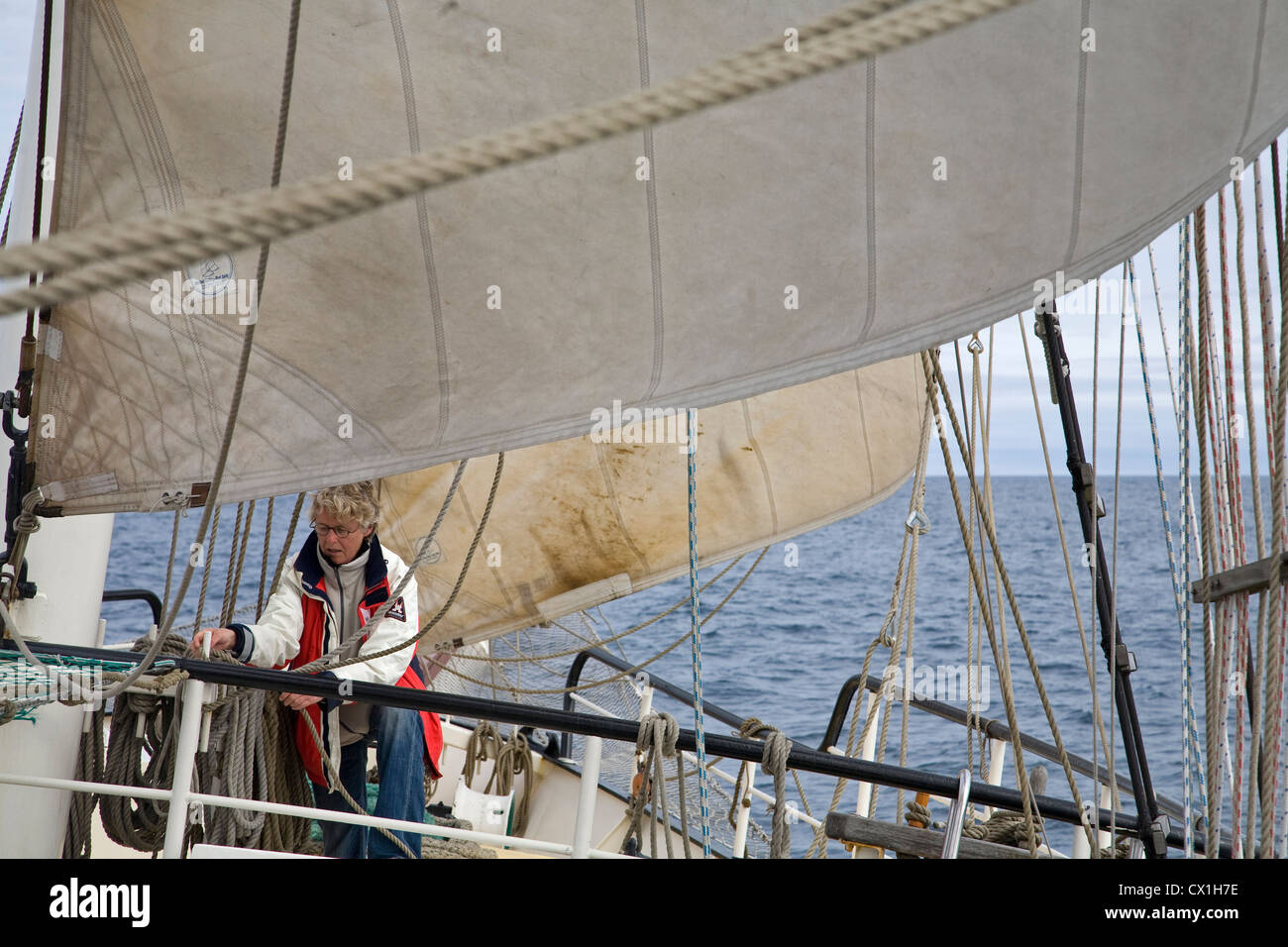 La manipulation des cordes de marin sur le pont du grand voilier trois-mâts barque-goélette / Antigua sailing auprès des touristes vers le Svalbard, Spitzberg, Norvège Banque D'Images