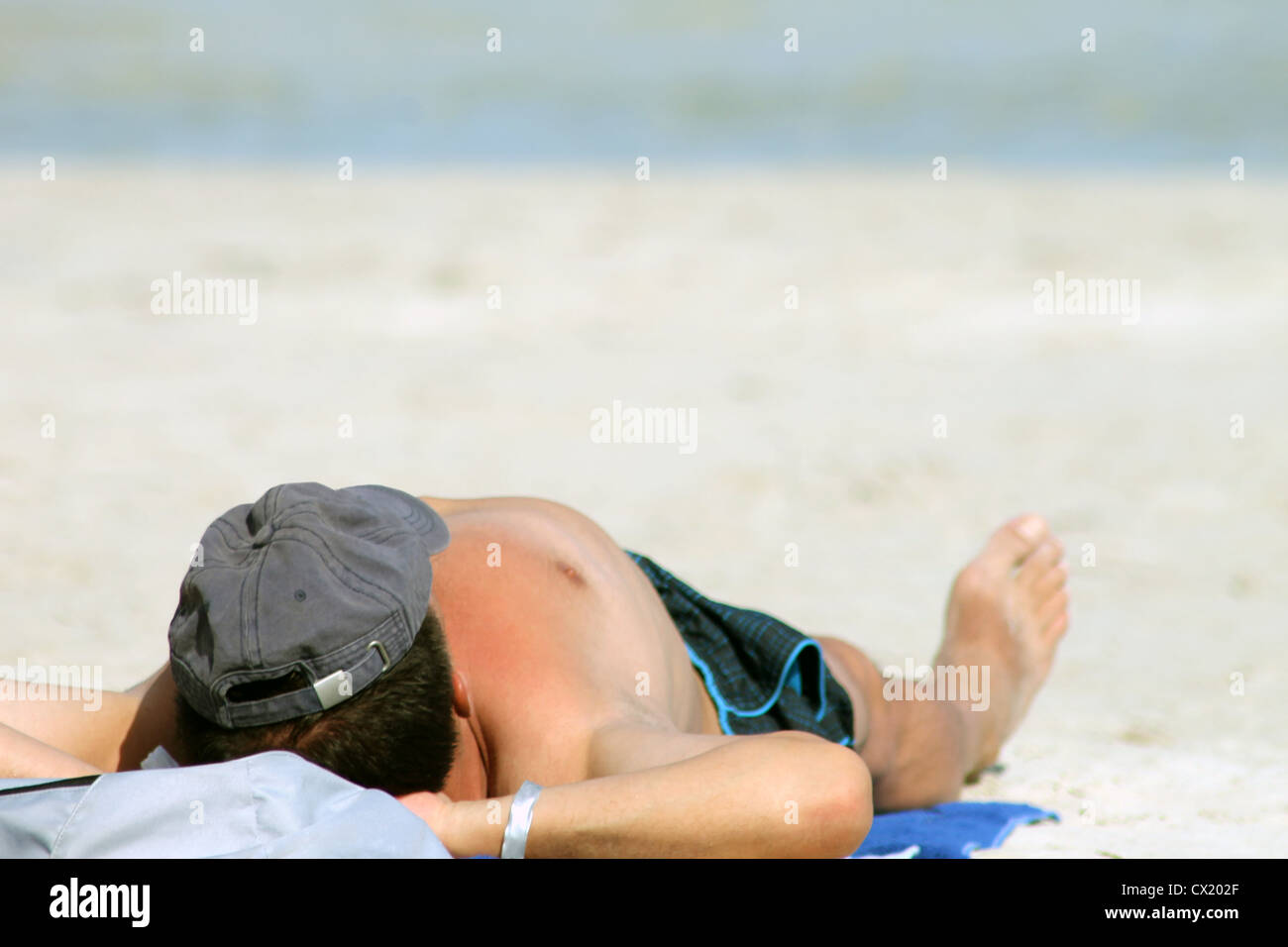Homme se faire bronzer sur la plage Banque de photographies et d’images
