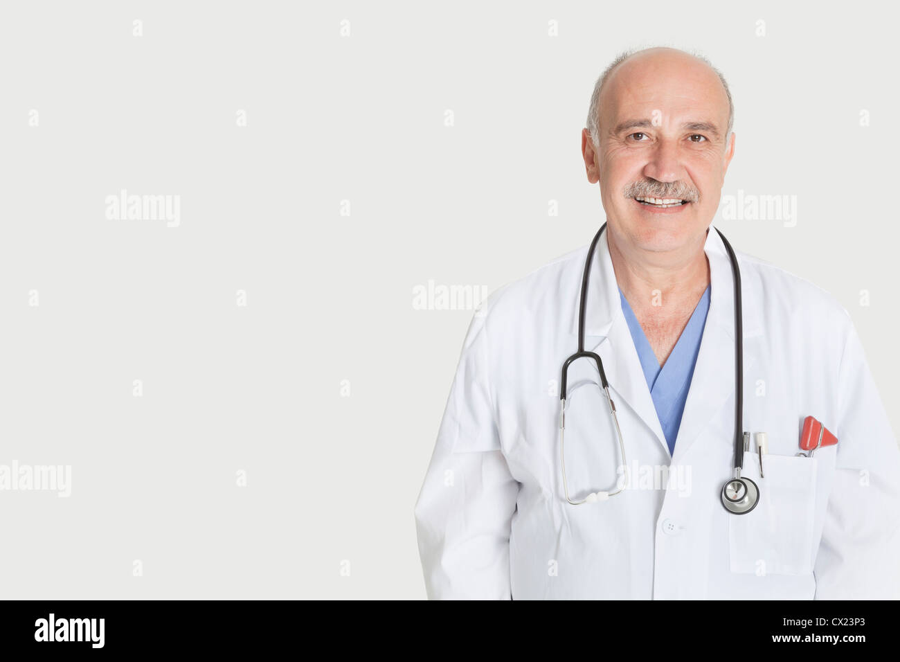 Portrait of happy senior médecin sur fond gris Banque D'Images