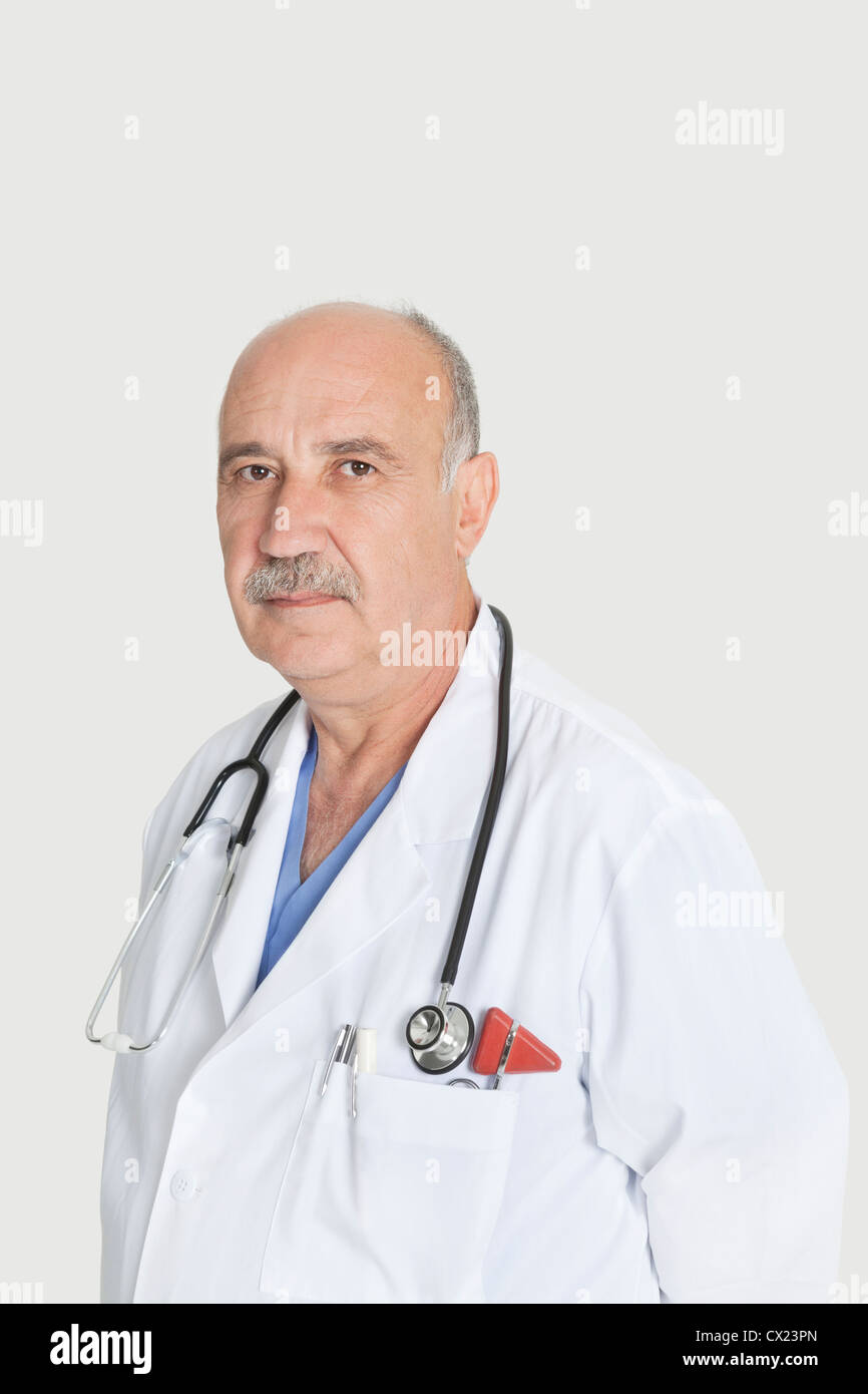 Portrait de senior sérieux médecin sur fond gris Banque D'Images
