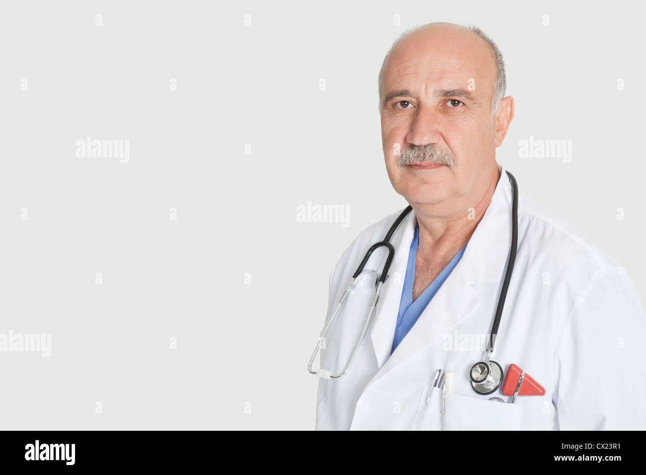 Portrait de senior sérieux médecin avec stéthoscope sur fond gris Banque D'Images