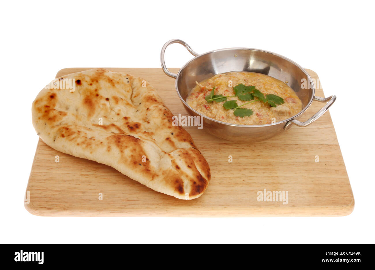 Poulet au curry balti dans un plat avec un pain naan sur une planche en bois isolés contre white Banque D'Images