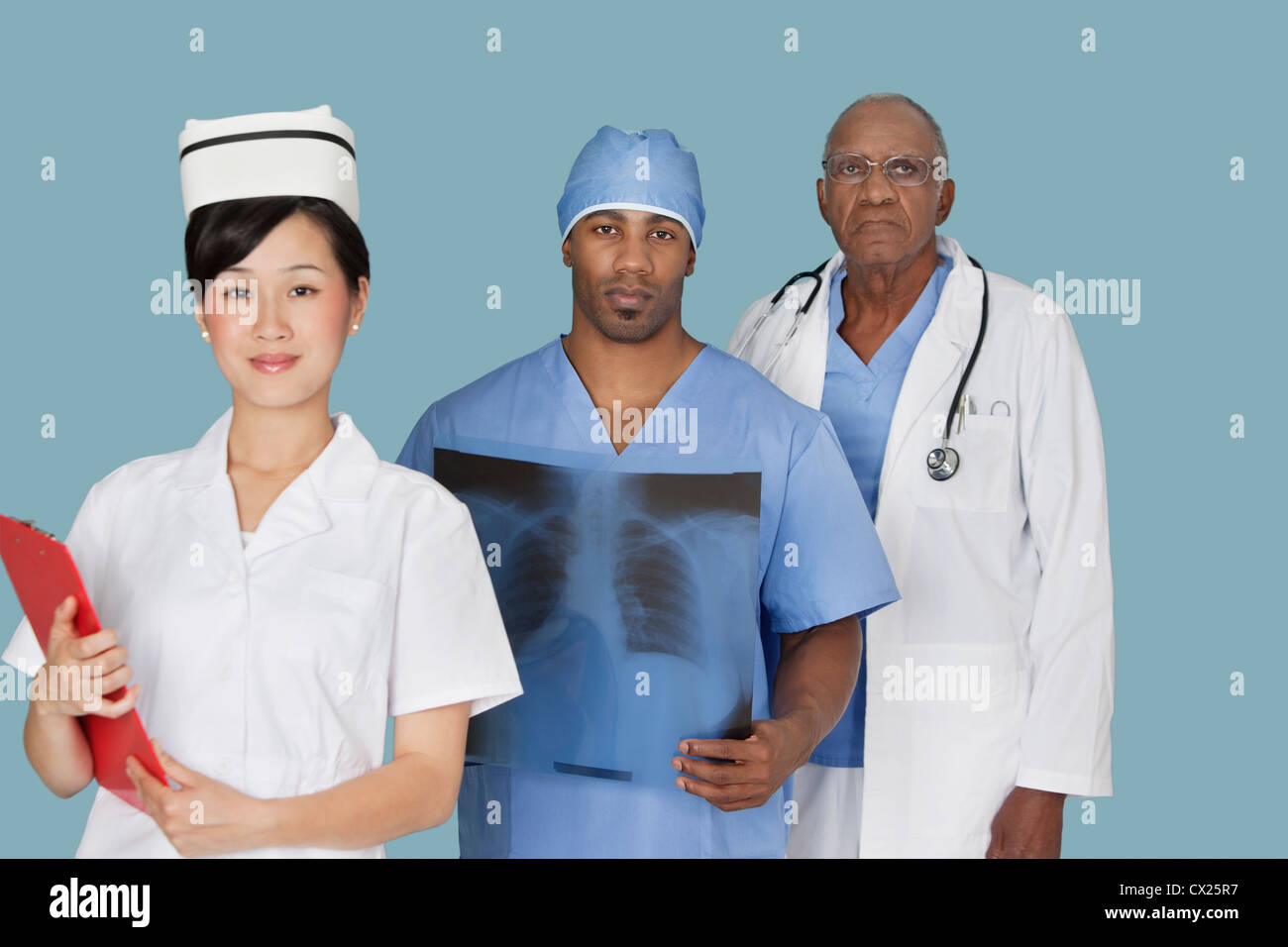 Portrait de trois professionnels médicaux multi ethnic sur fond bleu clair Banque D'Images
