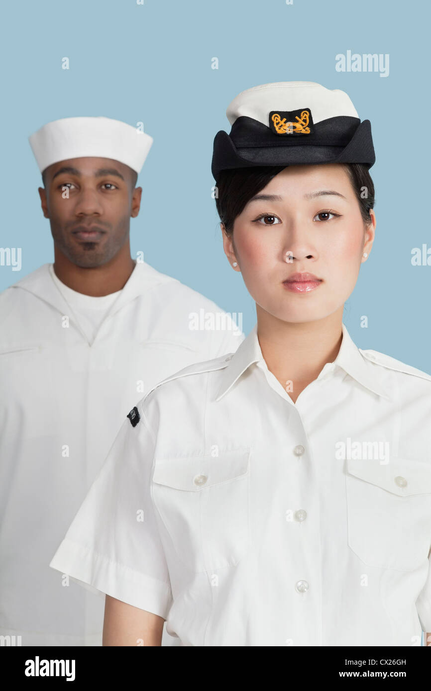 Portrait d'une femme officier de la Marine US devant marin masculin sur fond bleu clair Banque D'Images