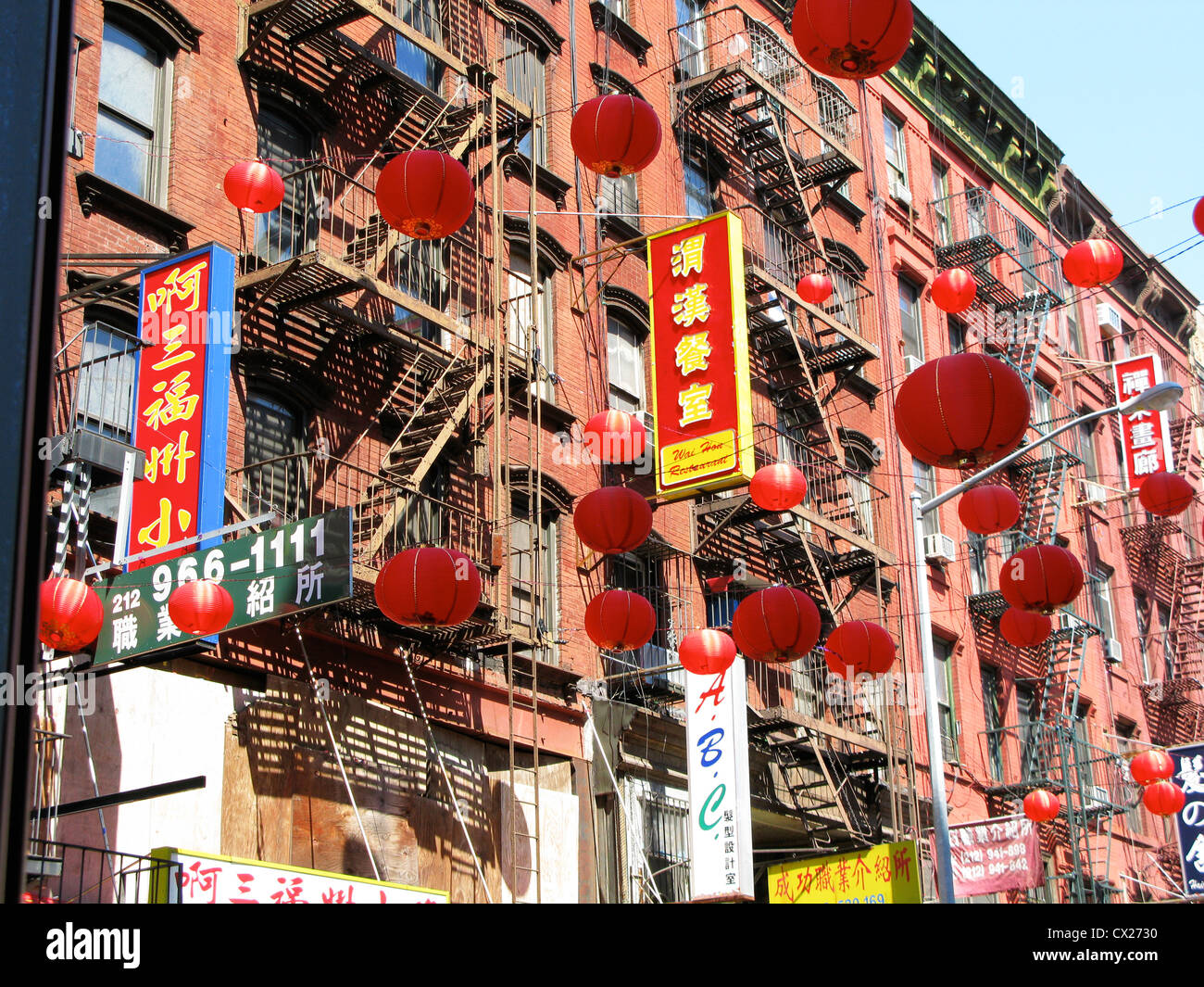 Lanternes rouge pendaison, néons chinois, issue de secours, d'un immeuble d'époque en briques, Chinatown, New York. Banque D'Images
