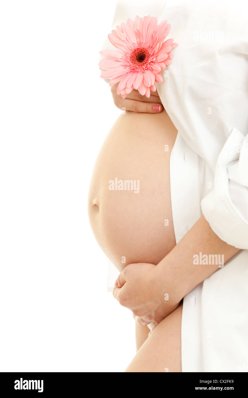 Ventre de femme enceinte (28 semaines) et rose fleur marguerite Banque D'Images