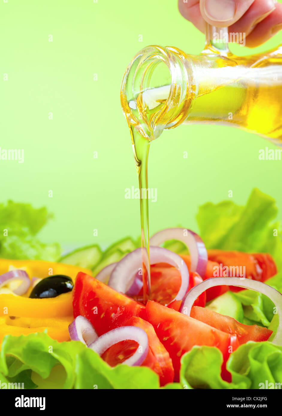 Flux de l'huile d'olive et salade de légumes frais et sain Banque D'Images
