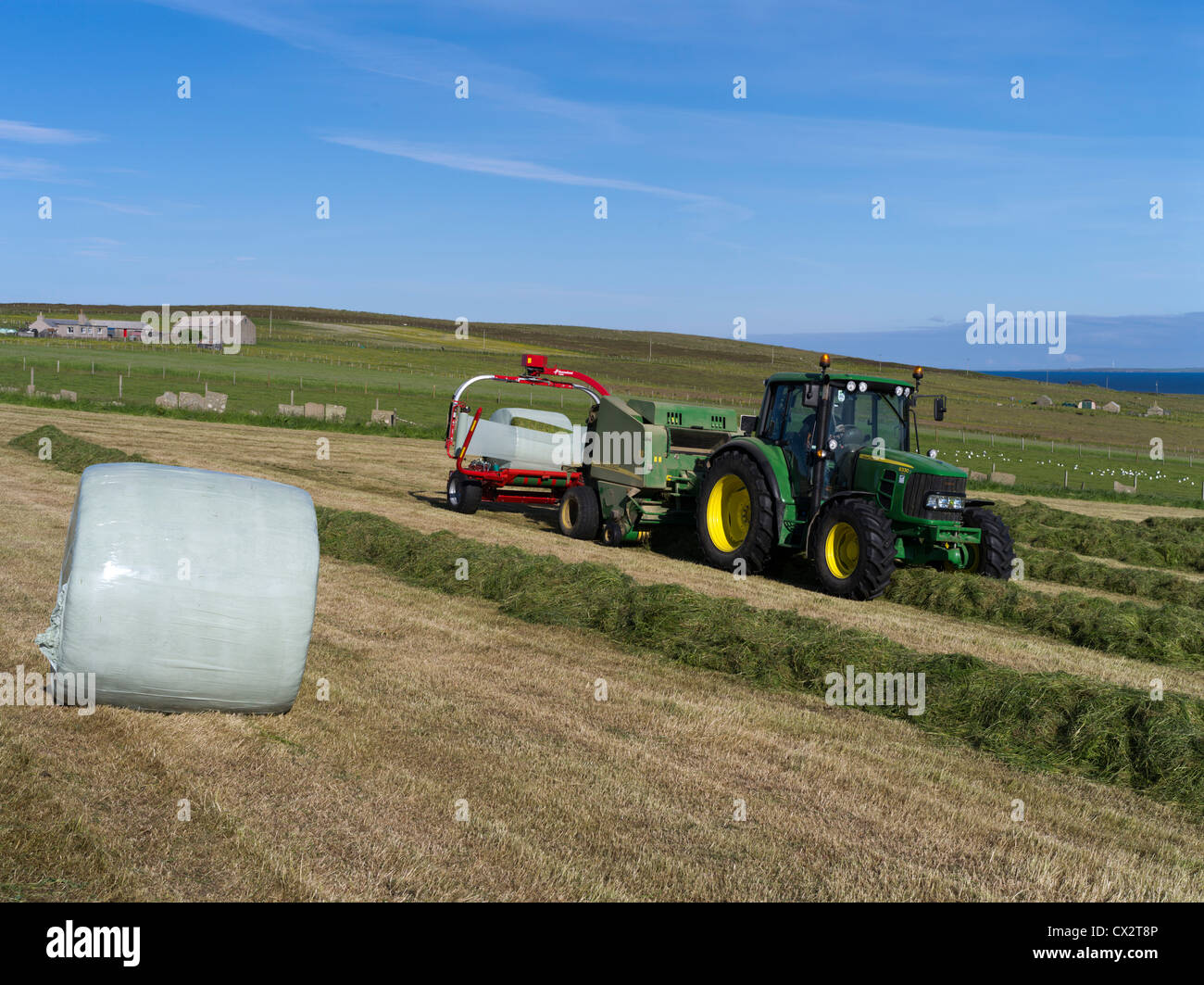 tracteur dh John Deere Brassing MOISSONNAGE au Royaume-Uni raclage sur le terrain récolte des balles machines presse à foin en Écosse tracteurs balles Banque D'Images