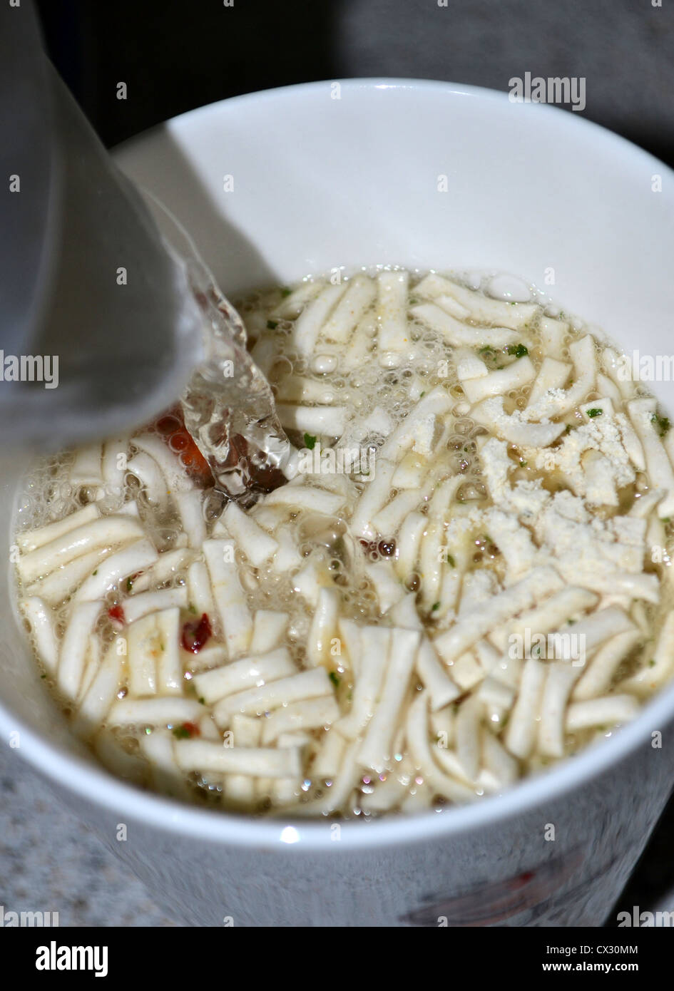Verser l'eau bouillante sur cup-a-soup noodles Banque D'Images