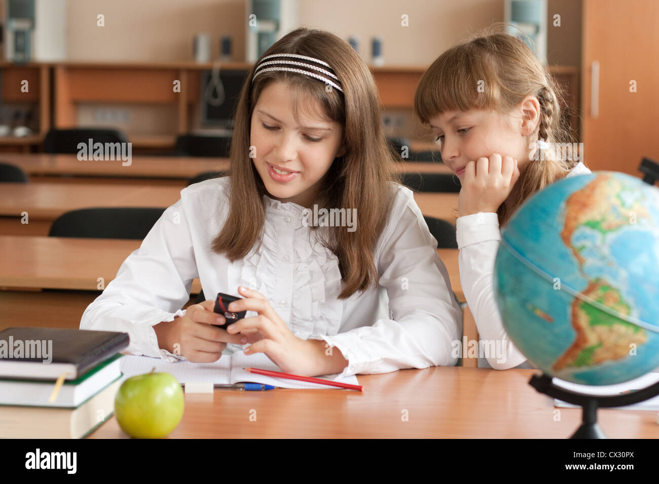 Deux filles sont à l'aide de téléphone mobile avec intérêt Banque D'Images