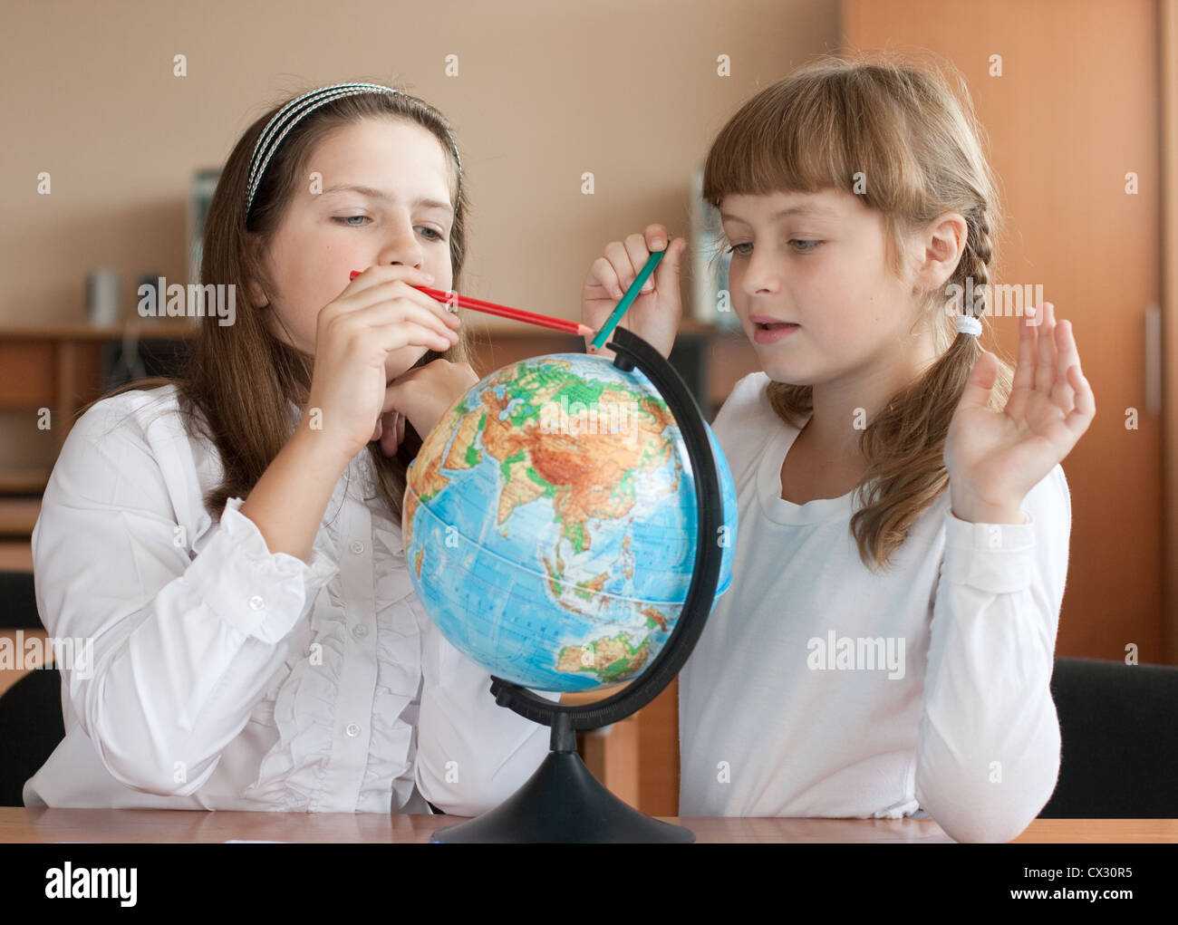 Deux écolières recherchez lieu géographique en utilisant globe Banque D'Images
