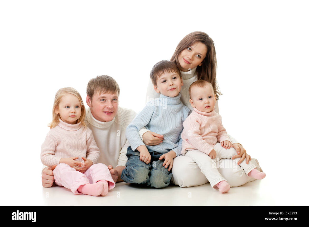 Happy Family sitting on floor et à la télévision, sur le côté, avec beaucoup d'intérêt Banque D'Images