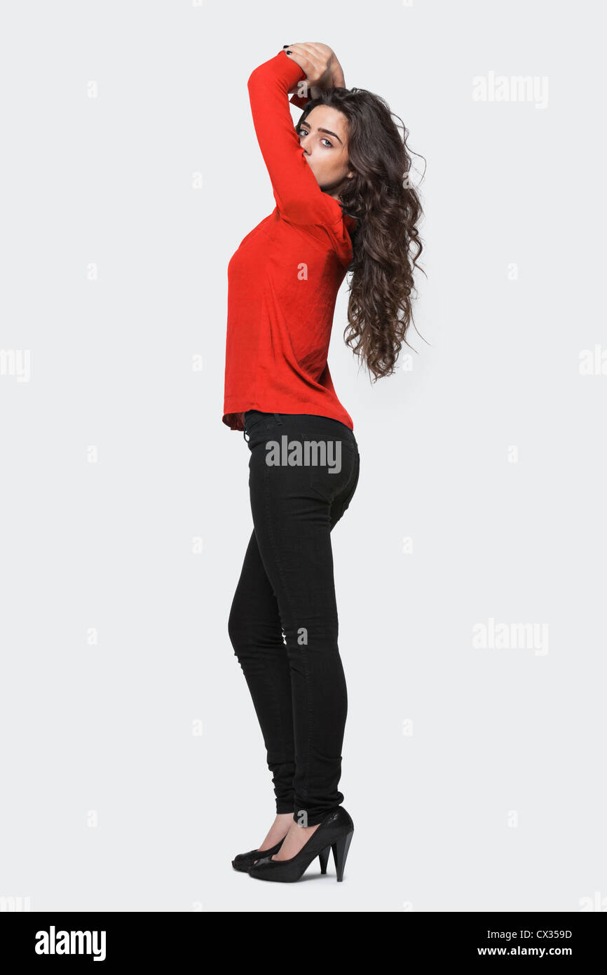 Vue de profil d'une jeune femme debout sur fond gris Banque D'Images