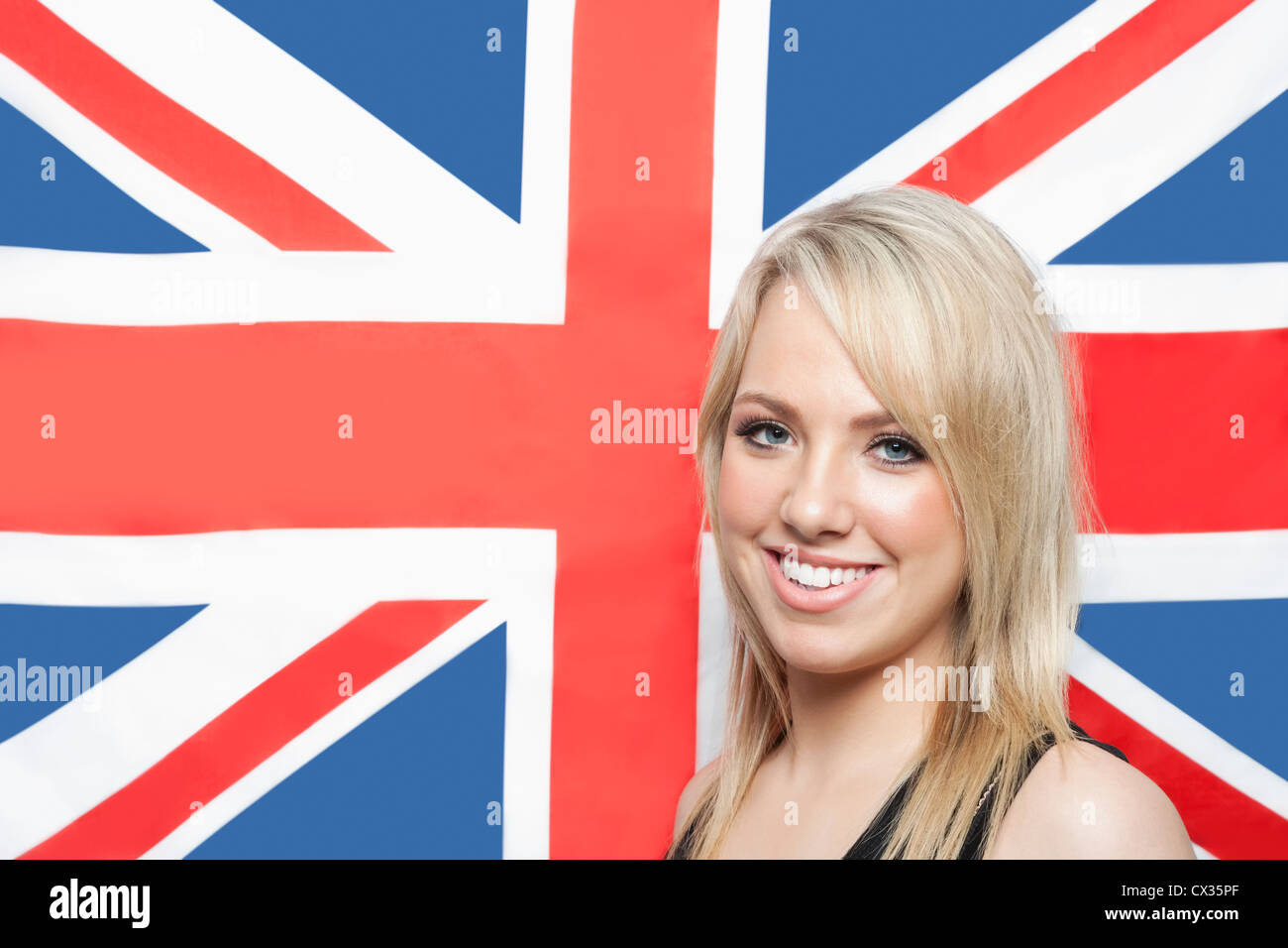 Portrait of happy young woman contre drapeau britannique Banque D'Images