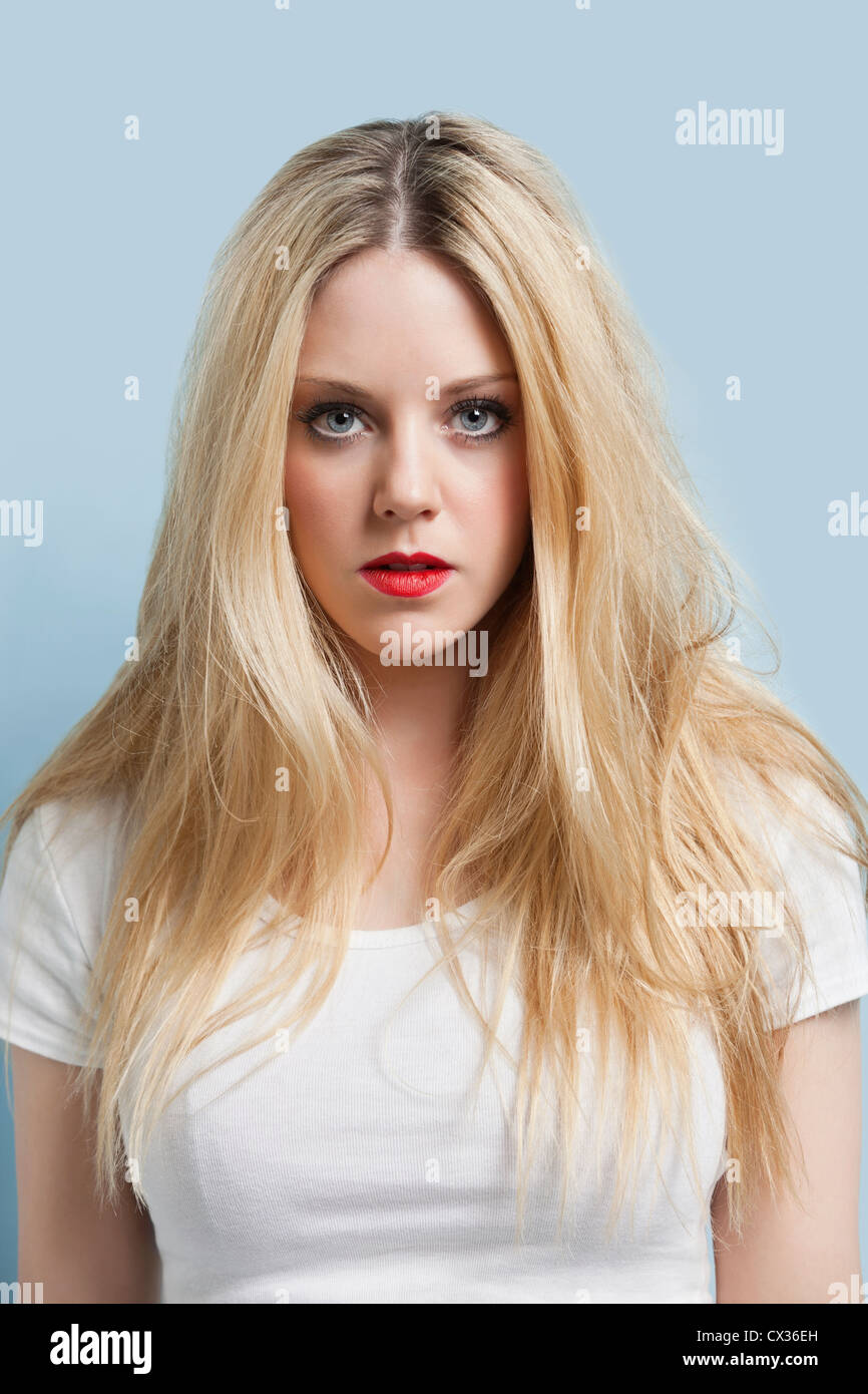 Portrait of attractive young blonde woman with red lips contre fond bleu clair Banque D'Images