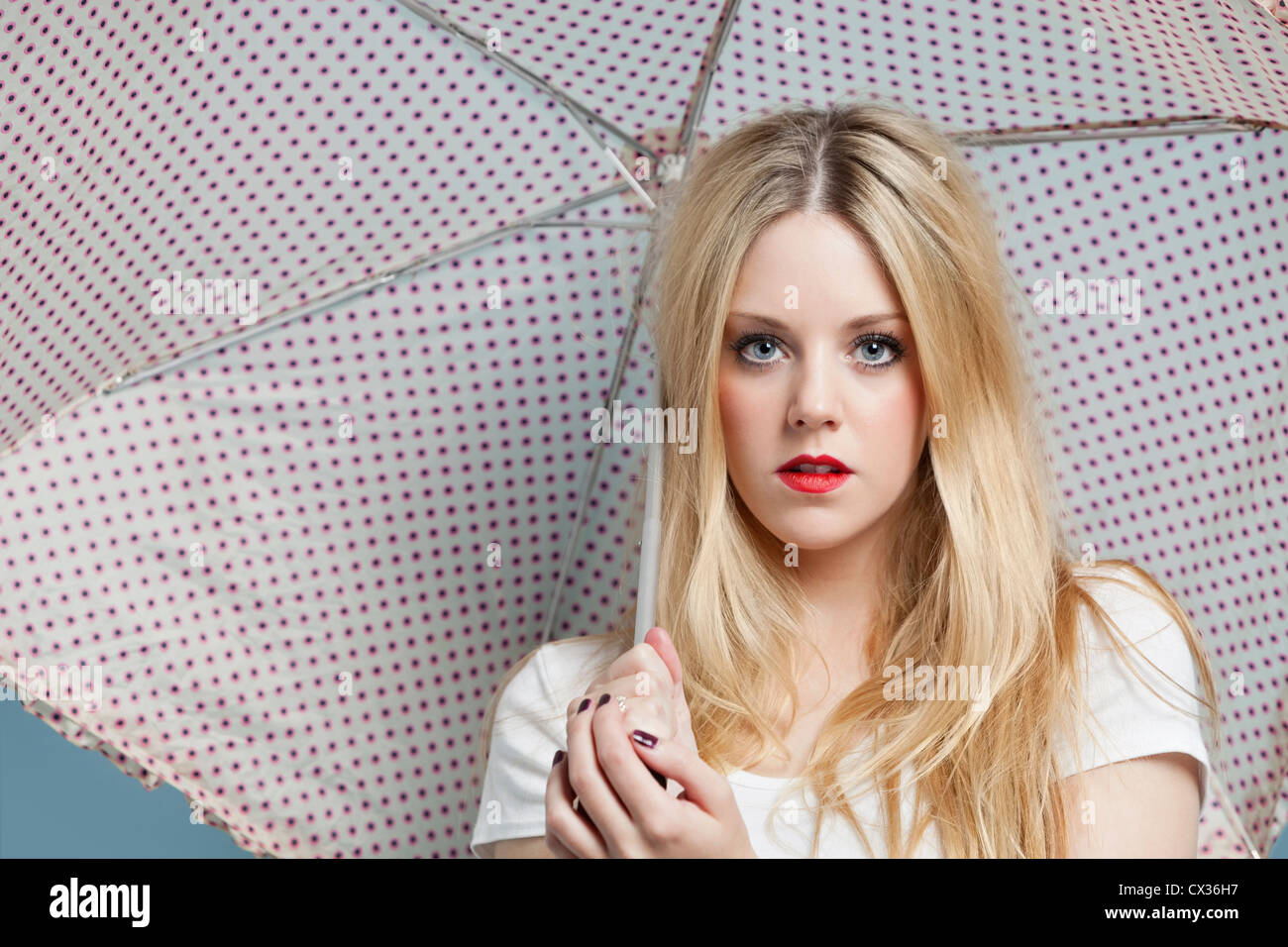 Close-up portrait of young woman holding parapluie à pois Banque D'Images