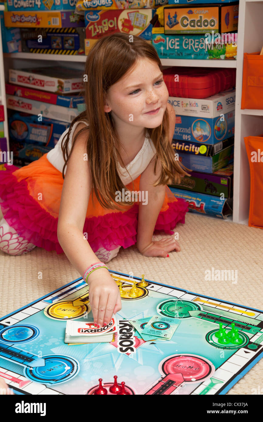 Une petite fille joue à un jeu de société. Banque D'Images