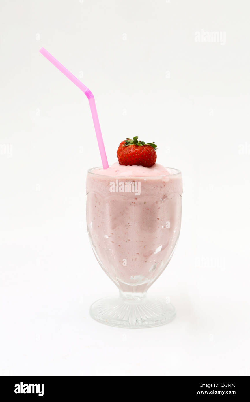 Lait frappé aux fraises dans un verre avec paille et fraises Banque D'Images
