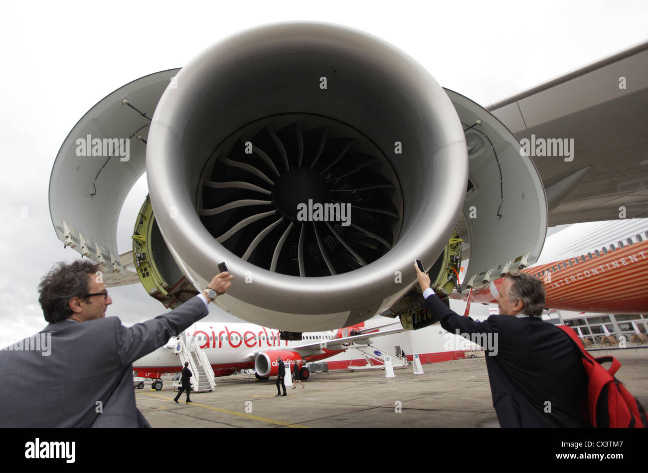 L'agence ITAR-TASS : PARIS, FRANCE. Le 21 juin 2011. Les hommes utilisent leur téléphone cellulaire / mobile pour photographier un moteur à réaction de son dernier avion de passagers, le 747-8 Intercontinental, au 2011 International Paris Air Show Le Bourget. (Photo l'agence ITAR-TASS/ Marina Lystseva) . . 21 . '-747-8' 49- ' - 2011' -. -/ Banque D'Images