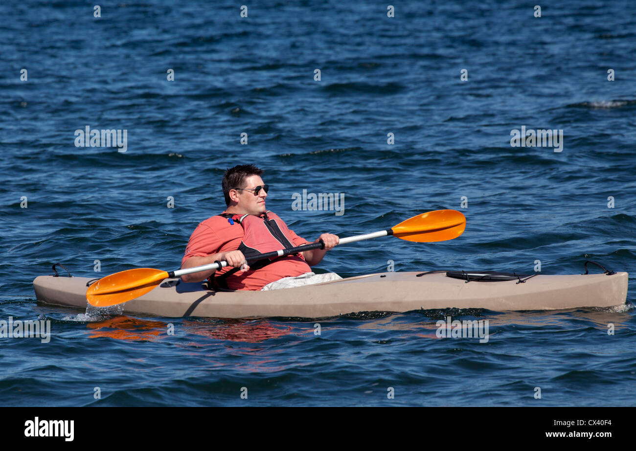Un grand homme dans un petit kayak. Banque D'Images