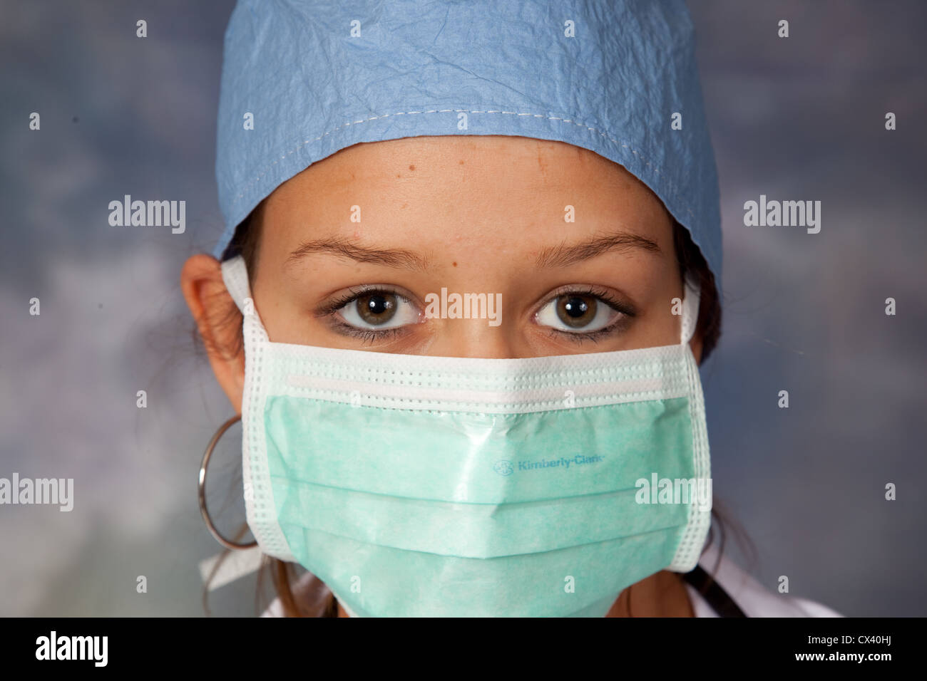 Travailleur de la santé des femmes, portant un sarrau blanc, scrub hat et s regardant la caméra Banque D'Images