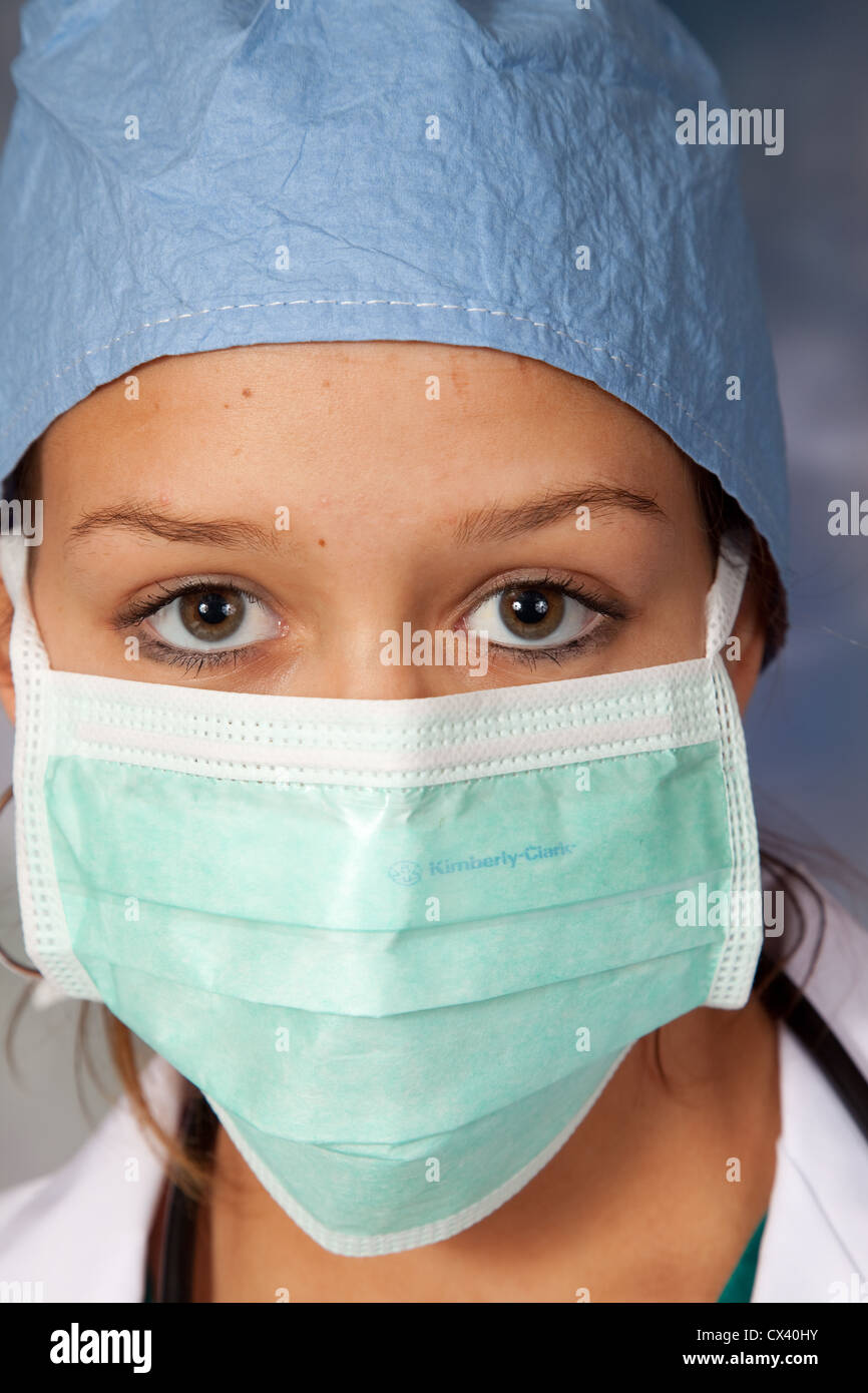 Travailleur de la santé des femmes, portant un sarrau blanc, scrub hat et stéthoscope autour de son cou, regardant la caméra Banque D'Images