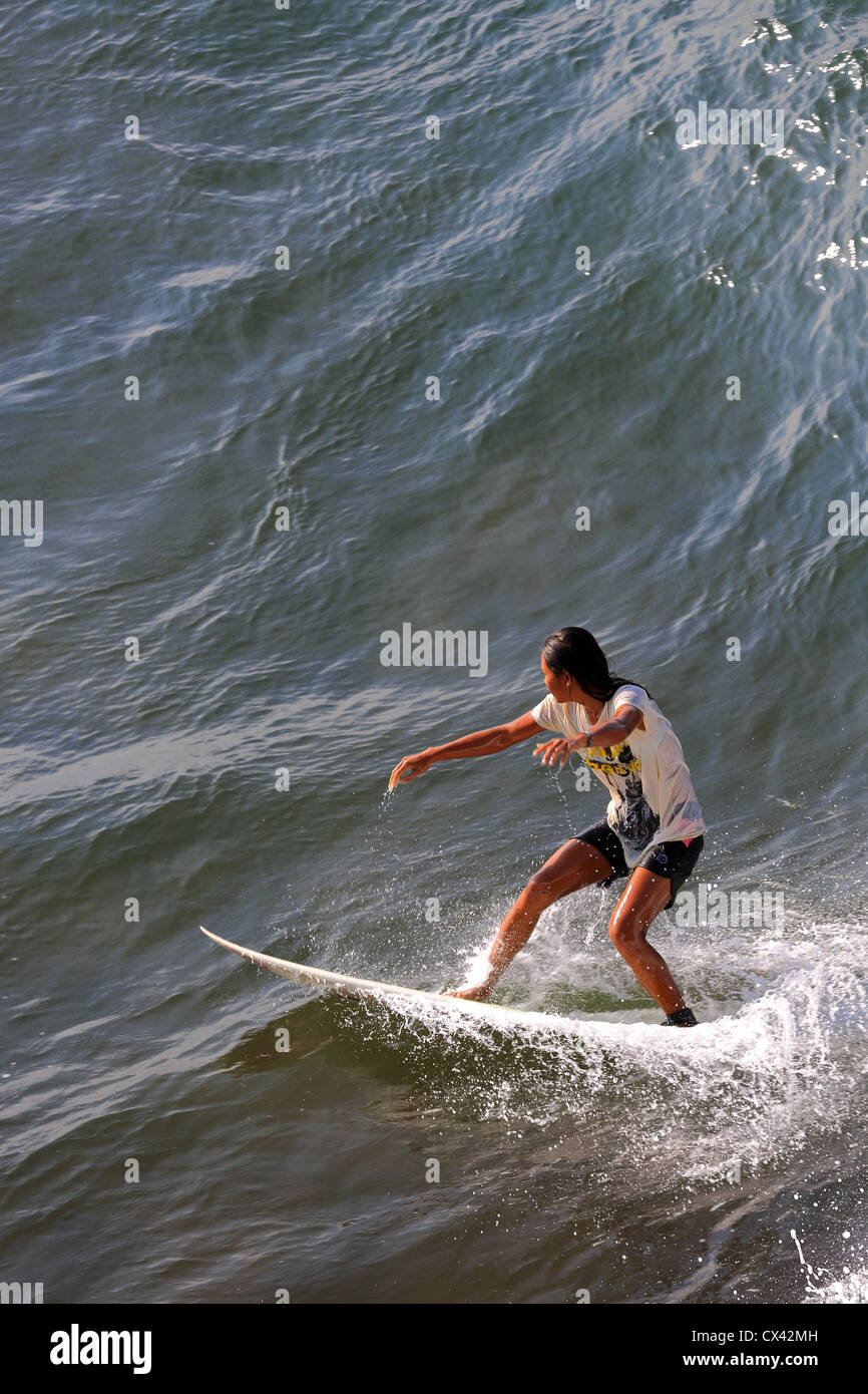 Fille Local surf une vague à Batu Karas à Java, en Indonésie Banque D'Images