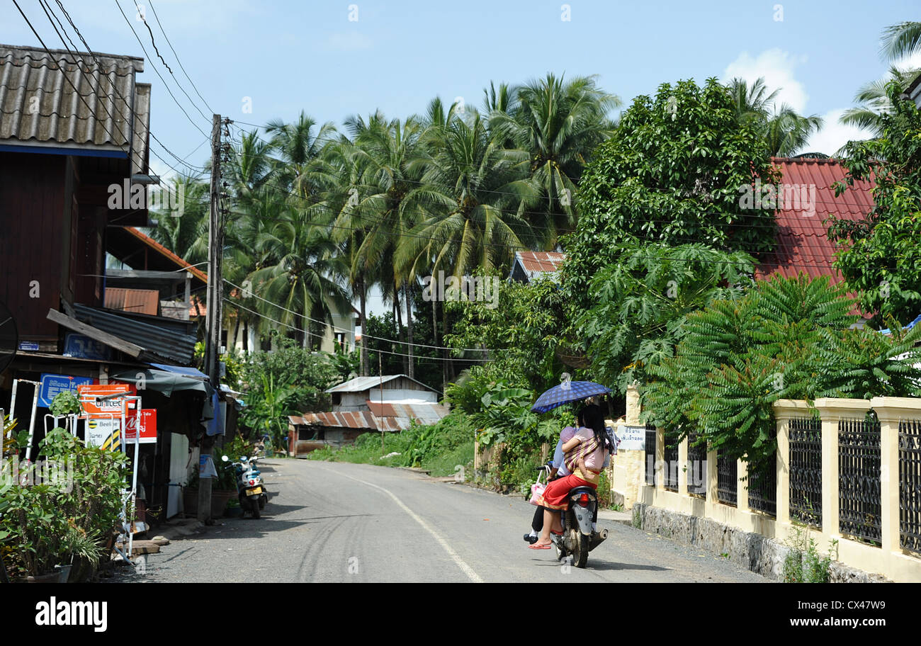 Family riding motorbike sur rue calme-route de Luang Prabang au Laos. Banque D'Images