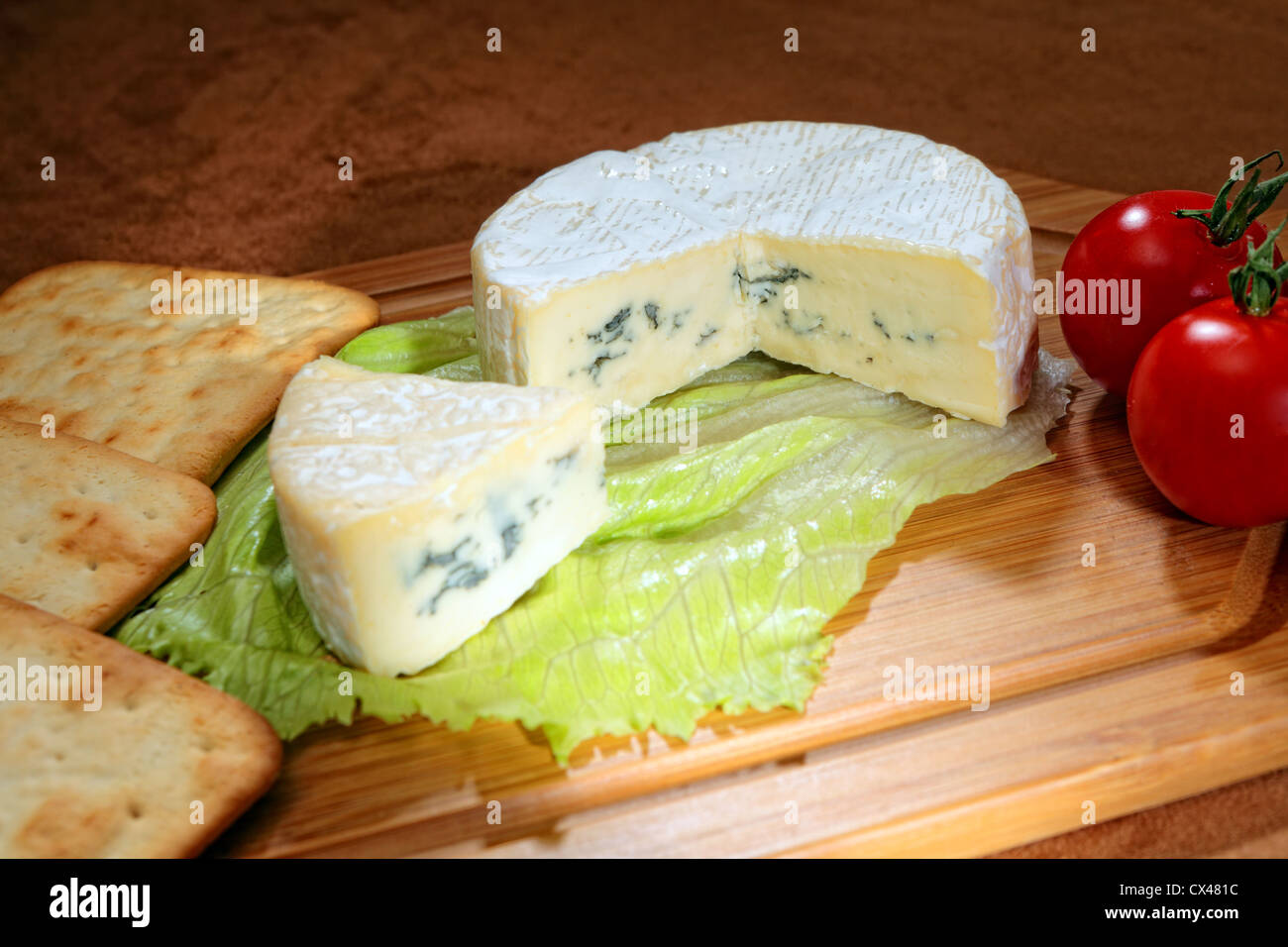 Une roue de camembert à pâte persillée avec tomates cerises et crème Biscuits Craquelins Banque D'Images