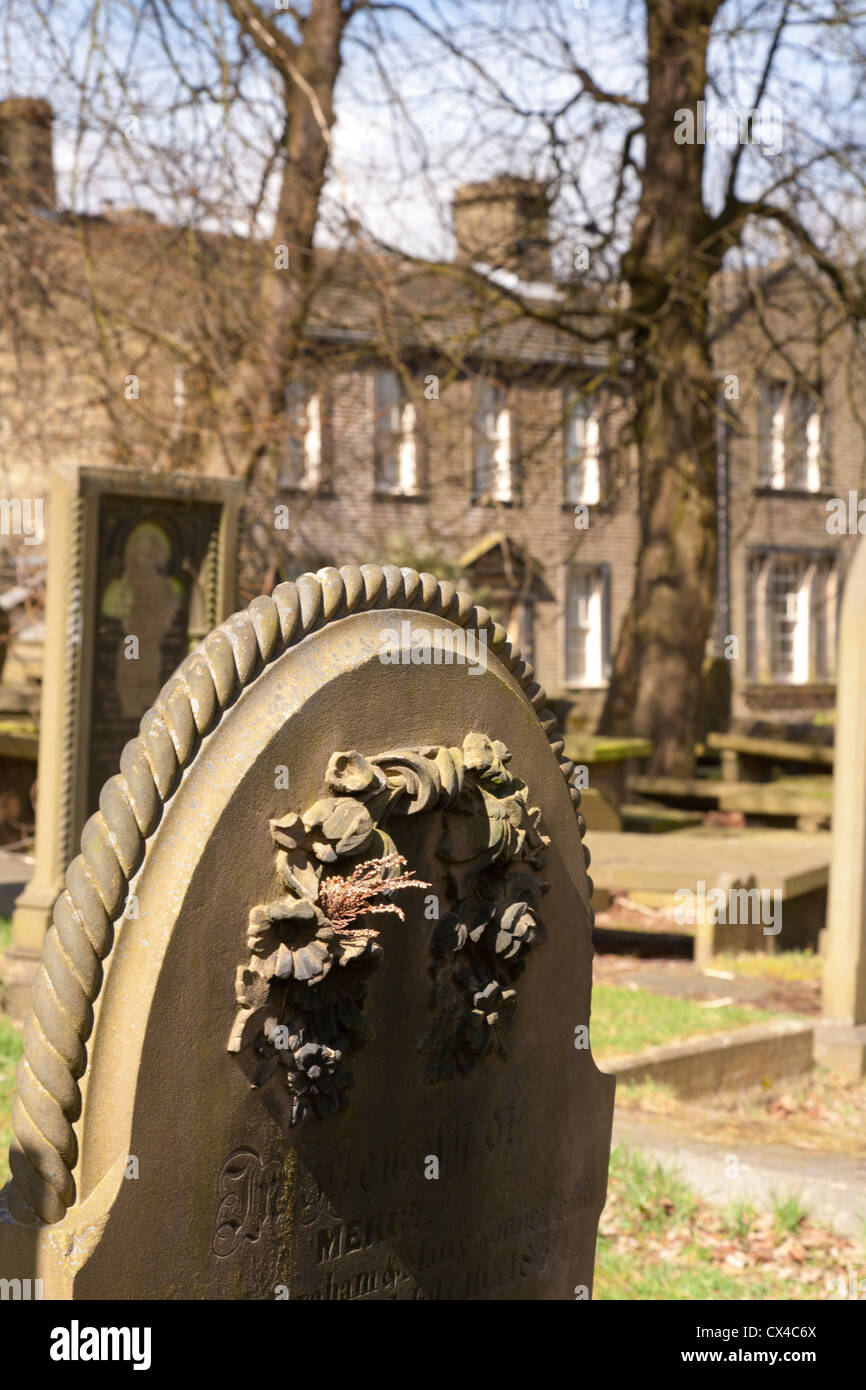 Pierre tombale dans Haworth cemetery, et the Bronte house derrière. L'accent sur pierre tombale. Banque D'Images