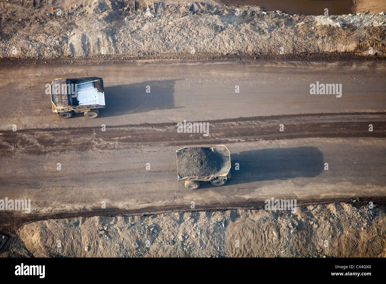 Décharge massive des camions chargés de sable bitumineux dans une mine au nord de Fort McMurray, Alberta, Canada. Banque D'Images