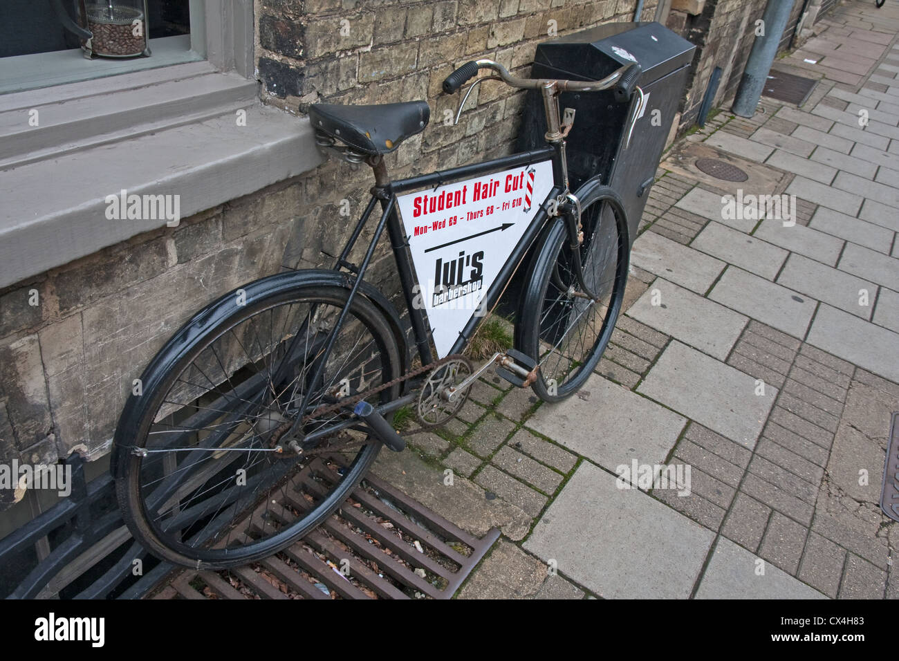 Vieux vélo publicité lui coiffure, Cambridge Banque D'Images