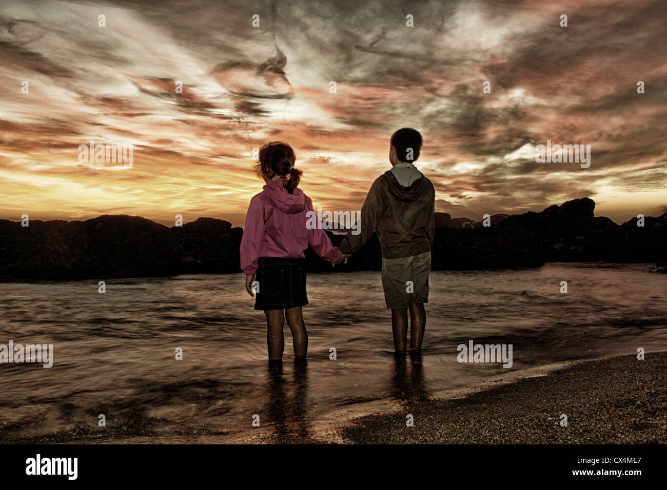 Deux enfants regardant un coucher de soleil en septembre majestueux agudela Beach au nord du Portugal Banque D'Images