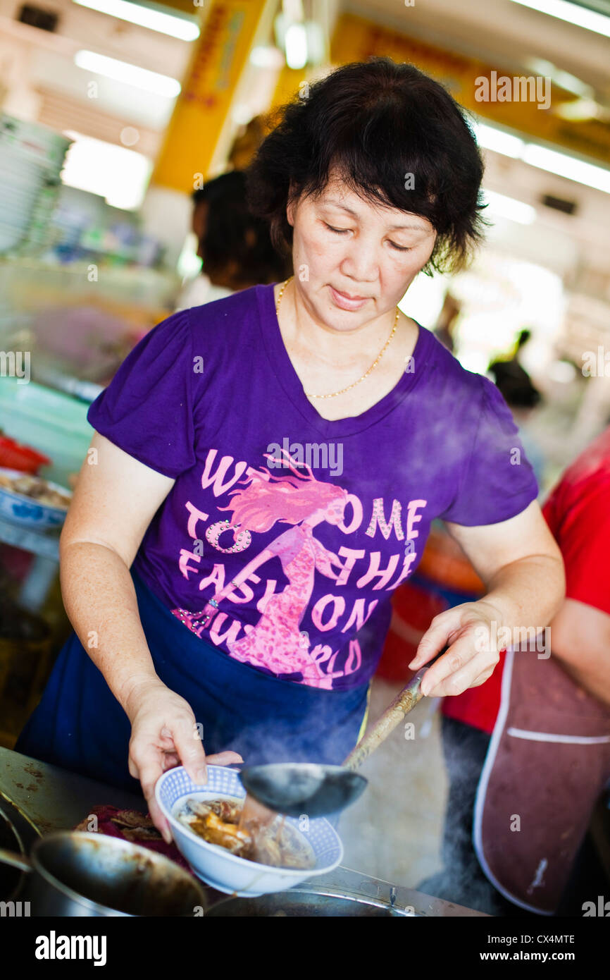 Femme préparant la soupe de nouilles dans un café traditionnel chinois. Kuching, Sarawak, Bornéo, Malaisie. Banque D'Images