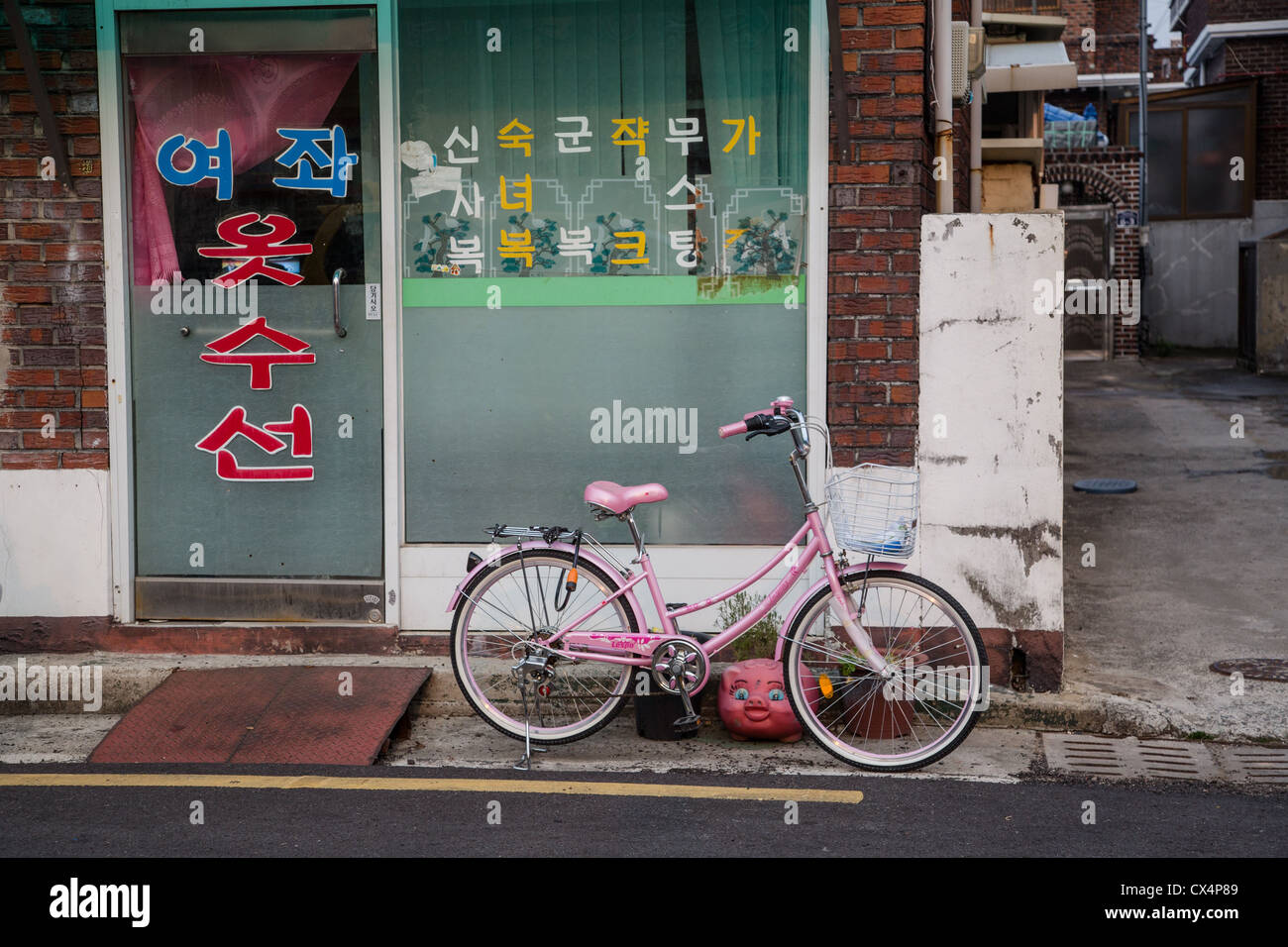 Store front sud-coréen - Vélo rose en face d'une ruelle Banque D'Images