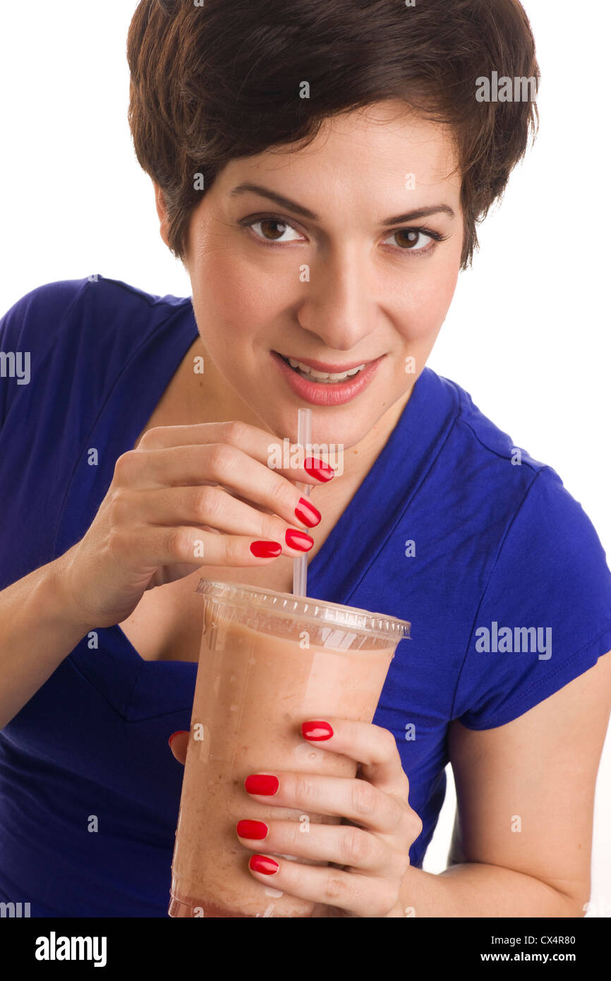 Belle femme avec des ongles manucurés gorgées un smoothie de couleur neutre Banque D'Images