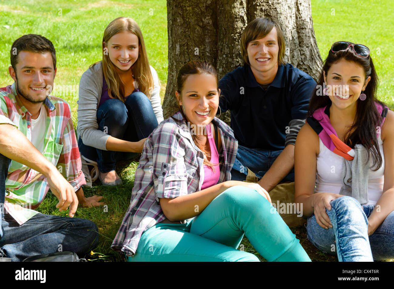 Students relaxing on meadow in adolescents happy group leisure park Banque D'Images
