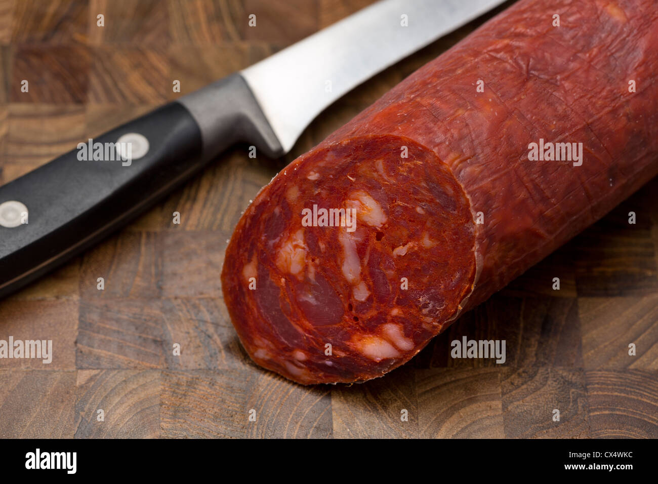 Saucisson Chorizo sur une carte à l'aide d'un couteau Banque D'Images