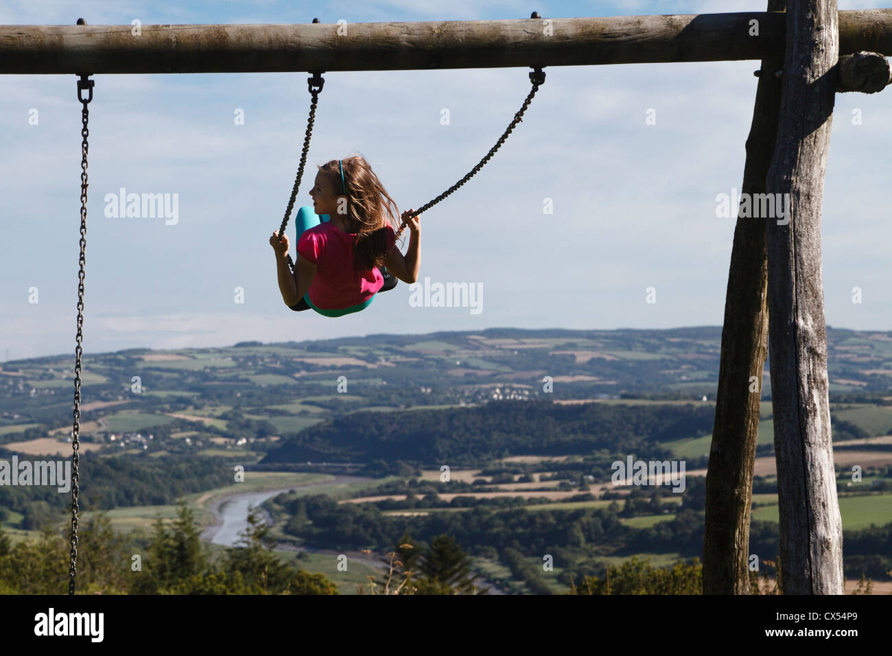 Jeune fille sur une balançoire avec une vue sur la vallée de l'Aulne à Dinéault, près de Chateaulin, Finistère, Bretagne, France Banque D'Images