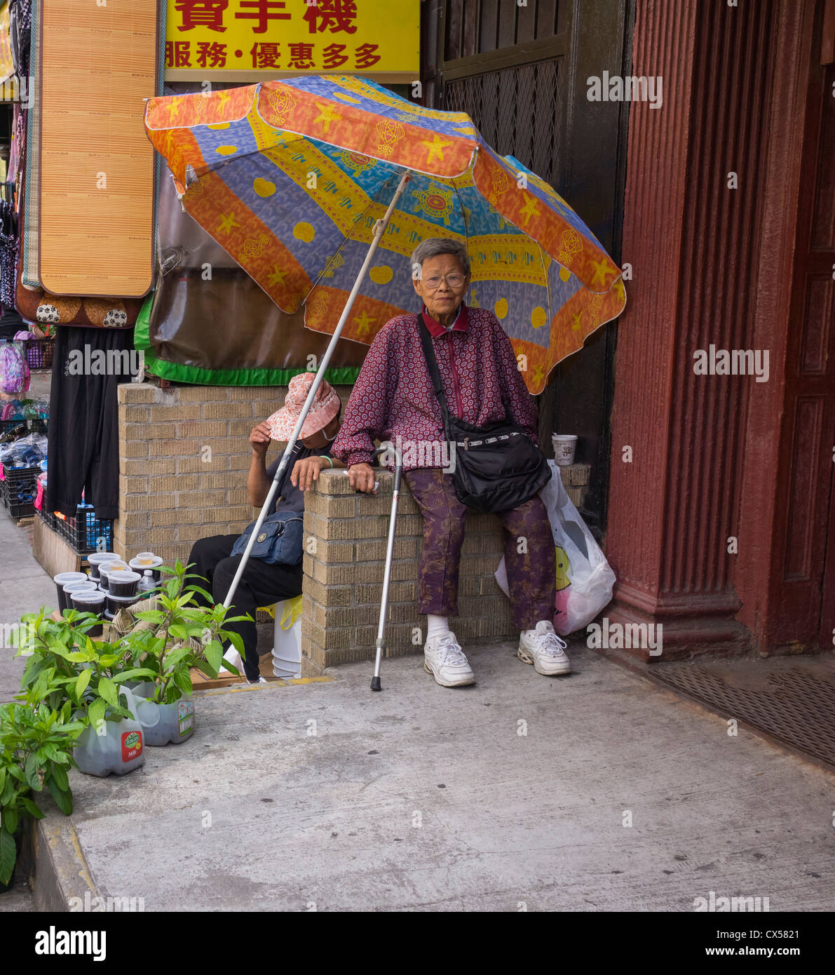 Deux hauts femmes asiatiques dans Chinatown New York à l'aide d'un grand parasol pour l'ombre Banque D'Images