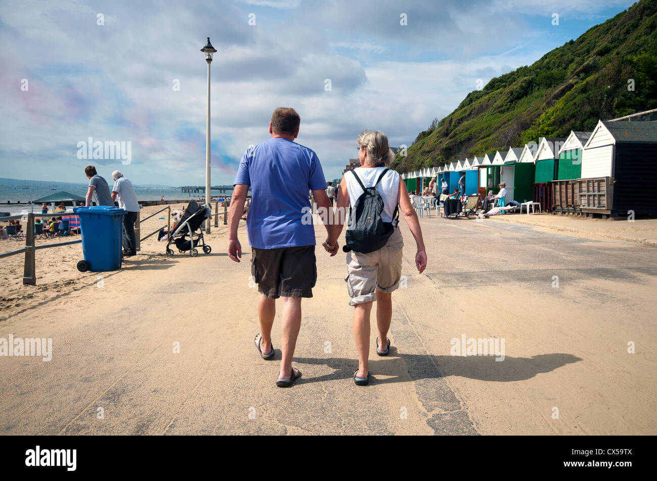 Couple holding hands walking down Southbourne, promenade vers la jetée de Boscombe Banque D'Images