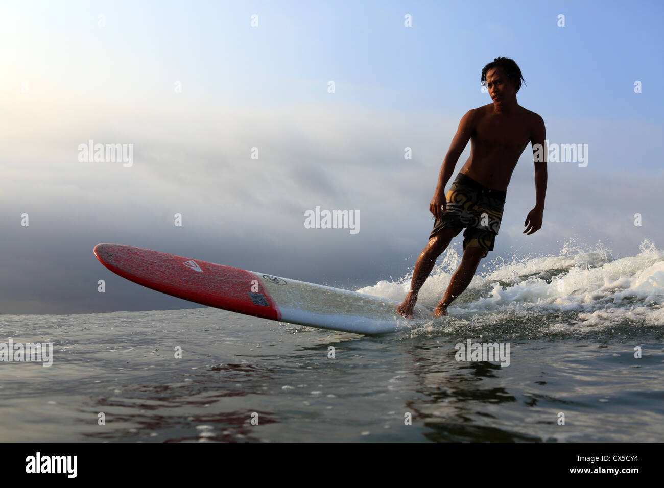 Surfer Local surf une vague à Batu Karas à Java, en Indonésie. Banque D'Images