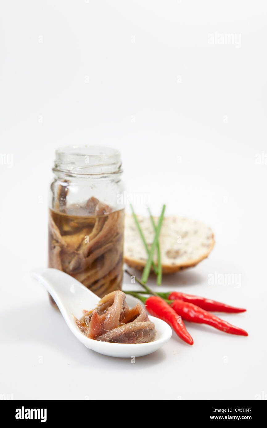 Anchois salés délicieux avec de l'huile sur fond blanc Banque D'Images