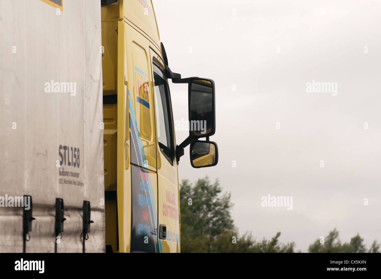 La cabine du camion avec le chauffeur vu dans le miroir de l'aile Banque D'Images