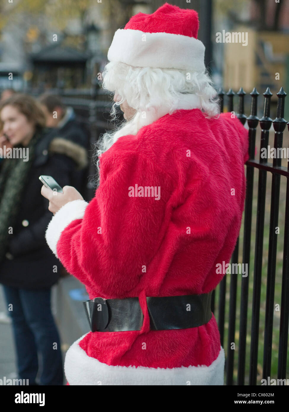 Un Père Noël des textos pendant Santa Con, un pub crawl avec des milliers habillé en père Noël, NYC, New York, USA Banque D'Images