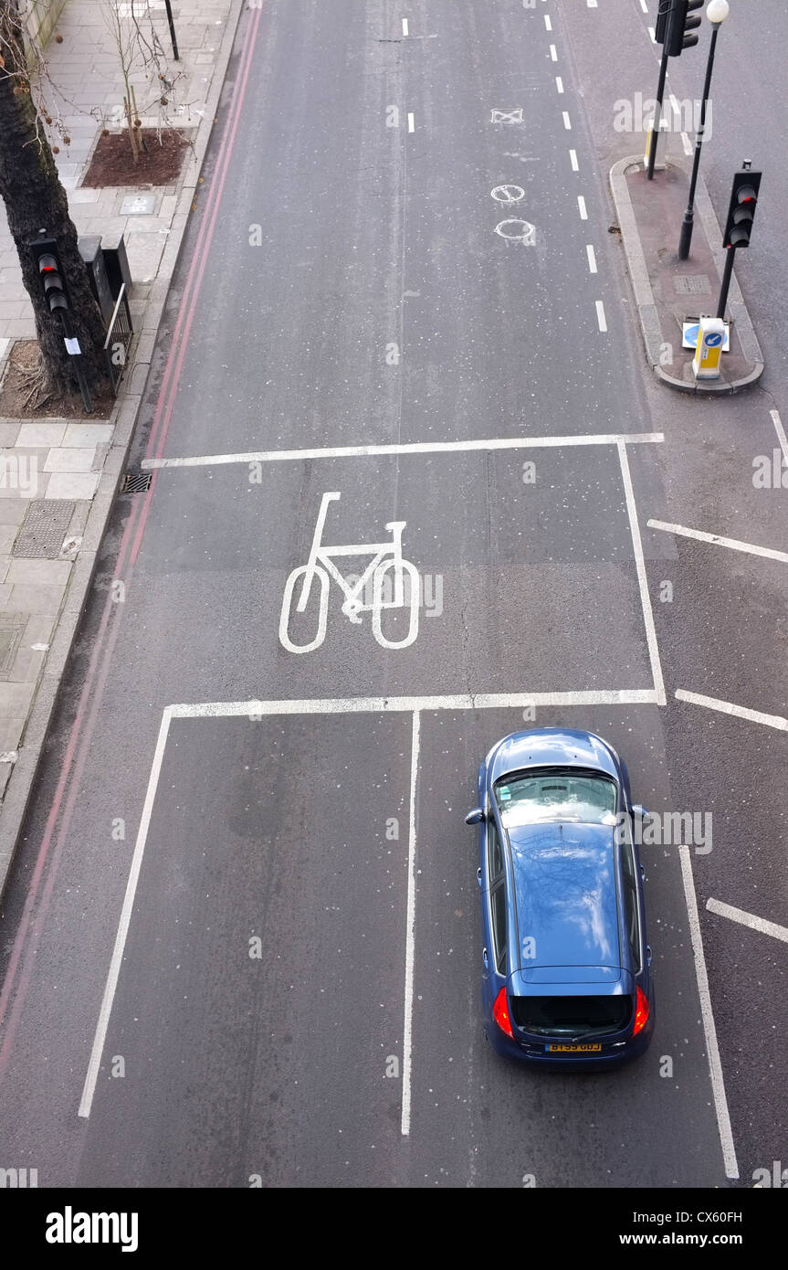 Une voiture s'arrêta à un feu rouge sur une route vide à côté d'une bande cyclable pris de dessus à Londres Banque D'Images