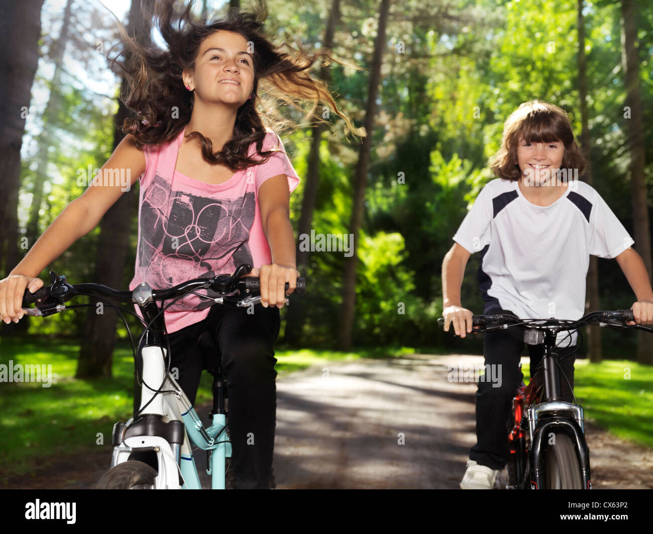 Deux happy smiling children enjoying balade à vélo dans un parc, frère et sœur, 10 et 13. L'été actif à l'extérieur de vie. Banque D'Images