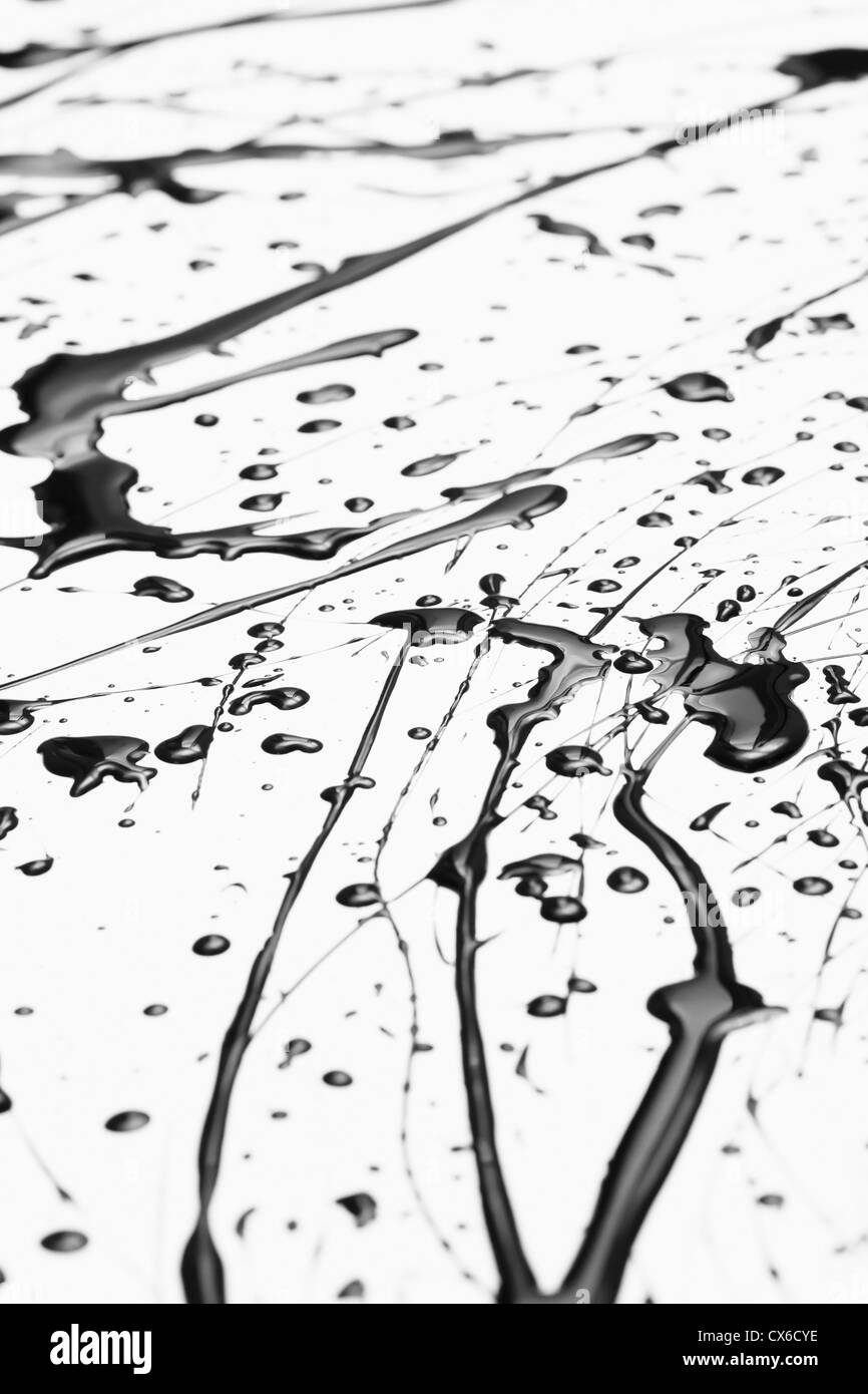 Splattered peinture noire faisant un motif abstrait complexe sur une surface blanche Banque D'Images