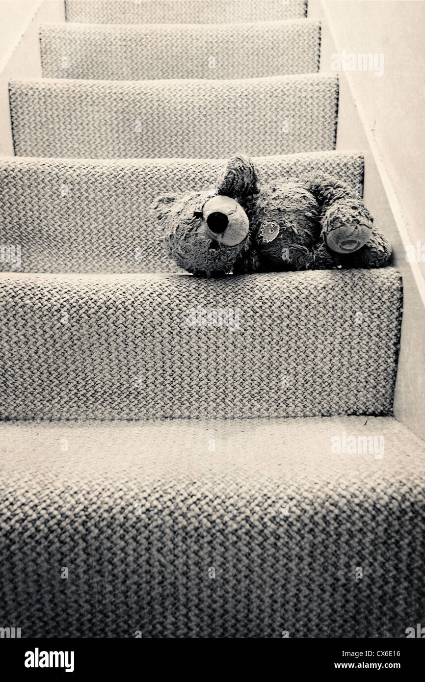 Un ours en peluche adoré bien couché sur l'escalier (sépia) Banque D'Images